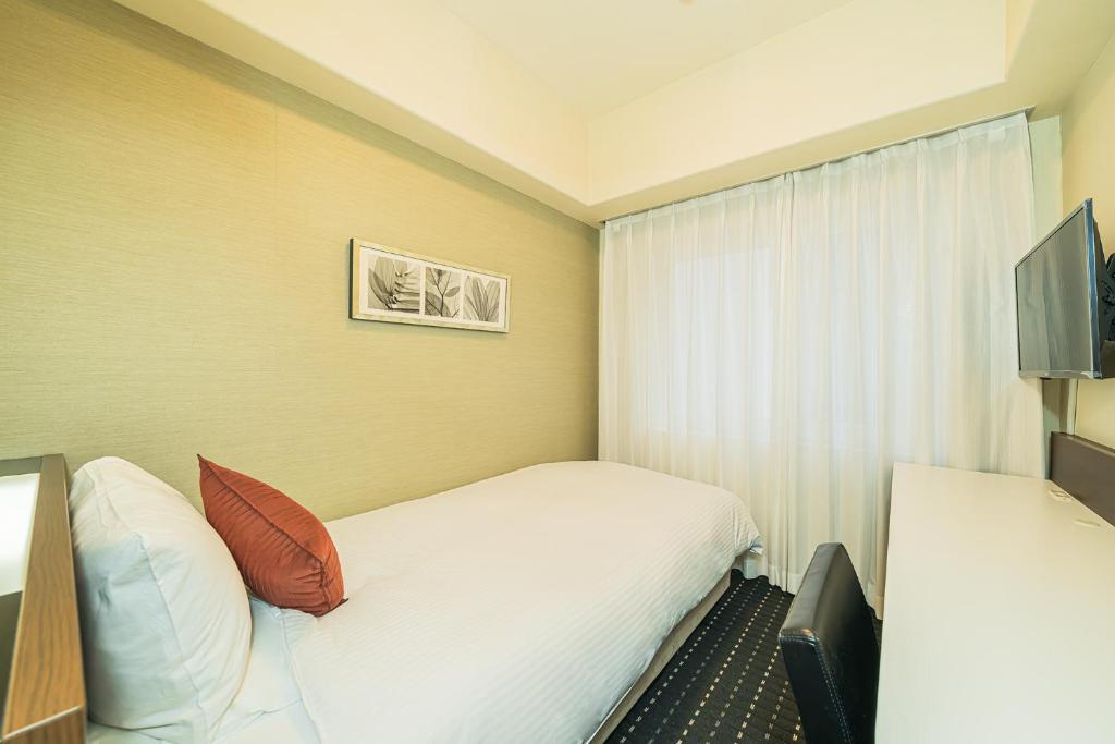 Postel nebo postele na pokoji v ubytování Kanda Station Hotel