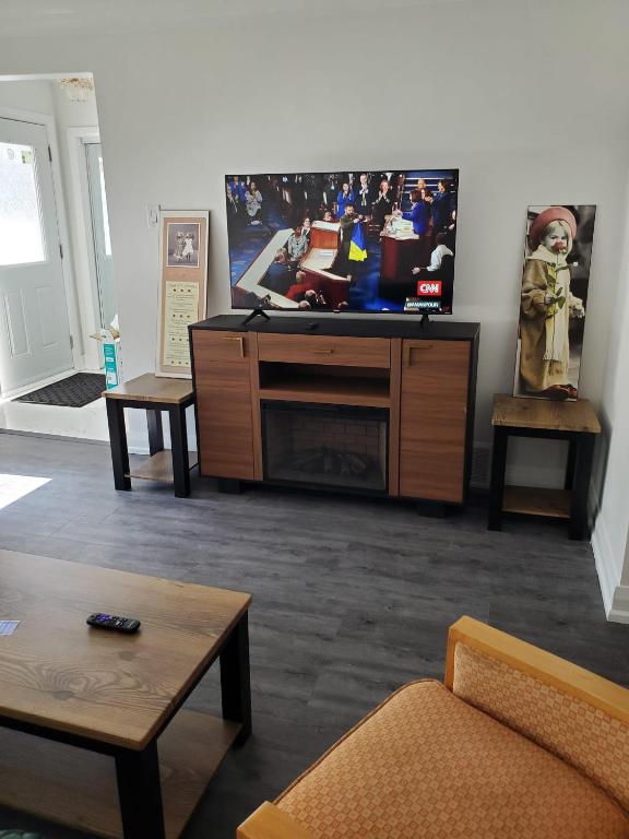 een woonkamer met een grote flatscreen-tv bij Maxwell Esabu in Toronto