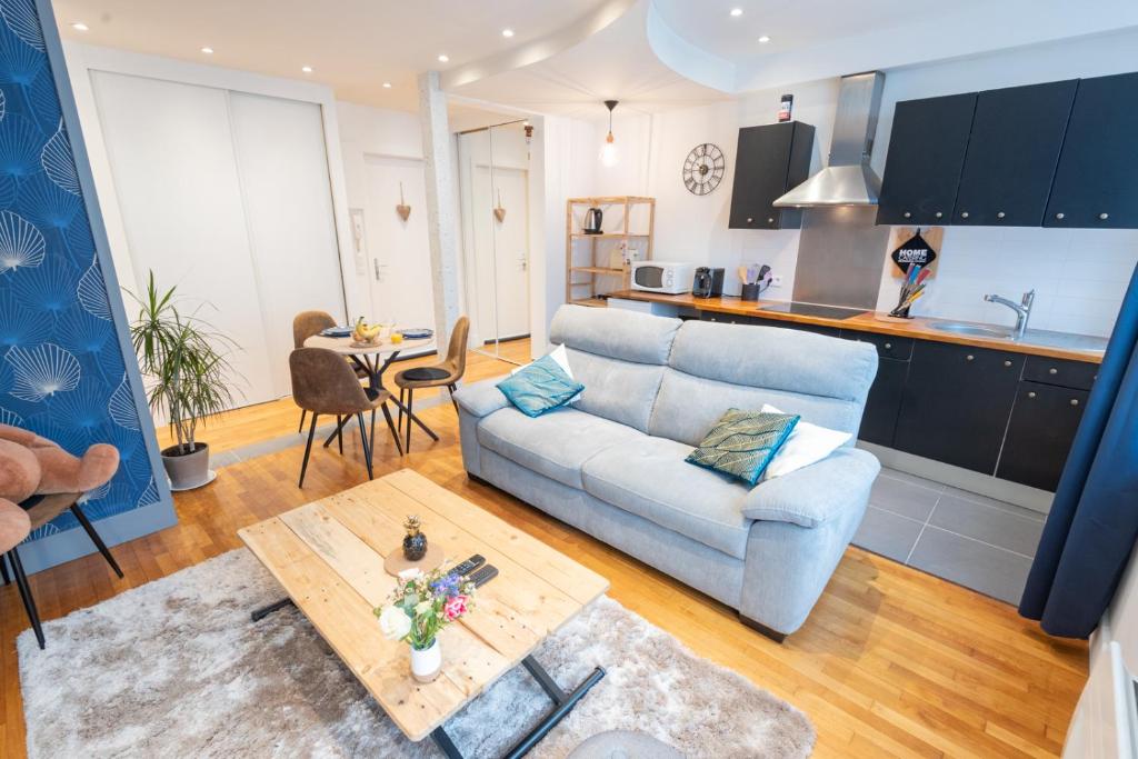 uma sala de estar com um sofá e uma mesa em Joli T2 tout équipé Quartier Piéton par Groom* em Lorient