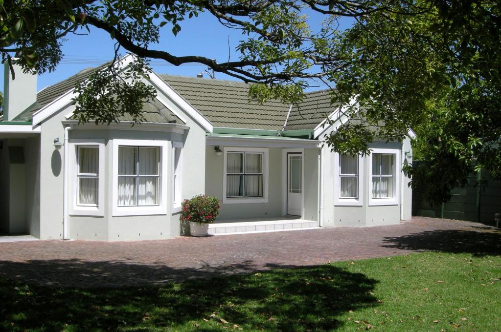 a white house with a lot of windows at Constantia Cottage in Cape Town