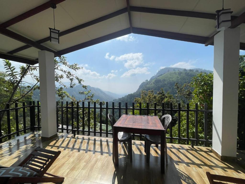 a table on a deck with a view of mountains at Divine View Homestay in Ella