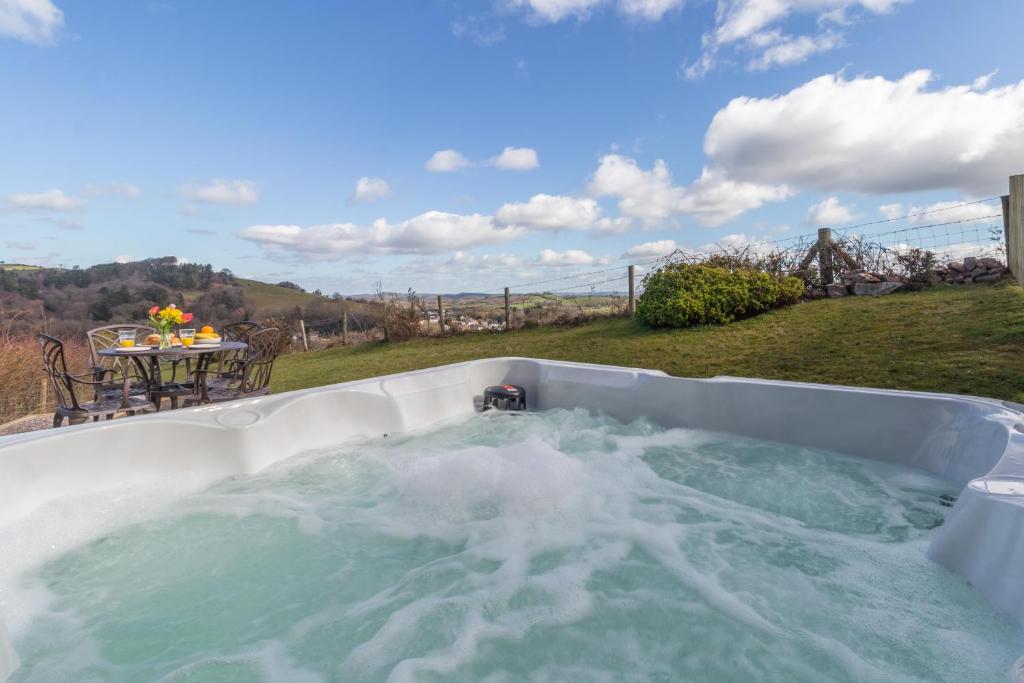 a hot tub with water in it in a yard at Bryn Gerrig View in Pontypool
