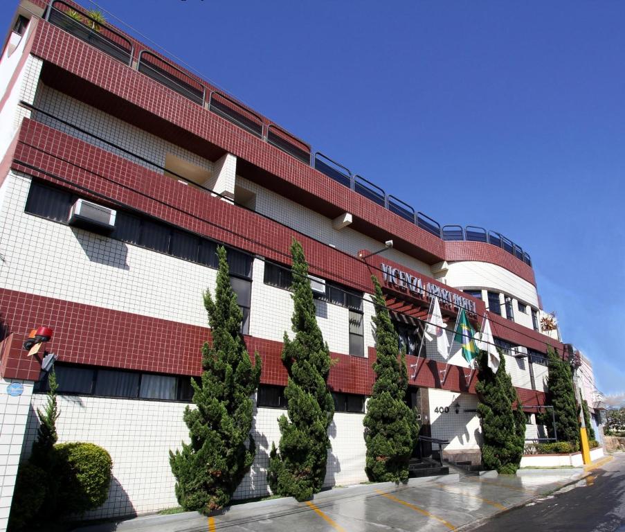 a building with trees in front of it at Vicenza Apart Hotel in São João del Rei