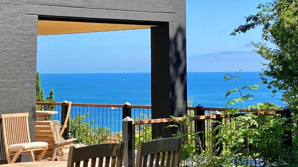 アリンエにあるModern Holiday Home With Exceptional Sea Viewsの海の景色を望むパティオ(椅子付)