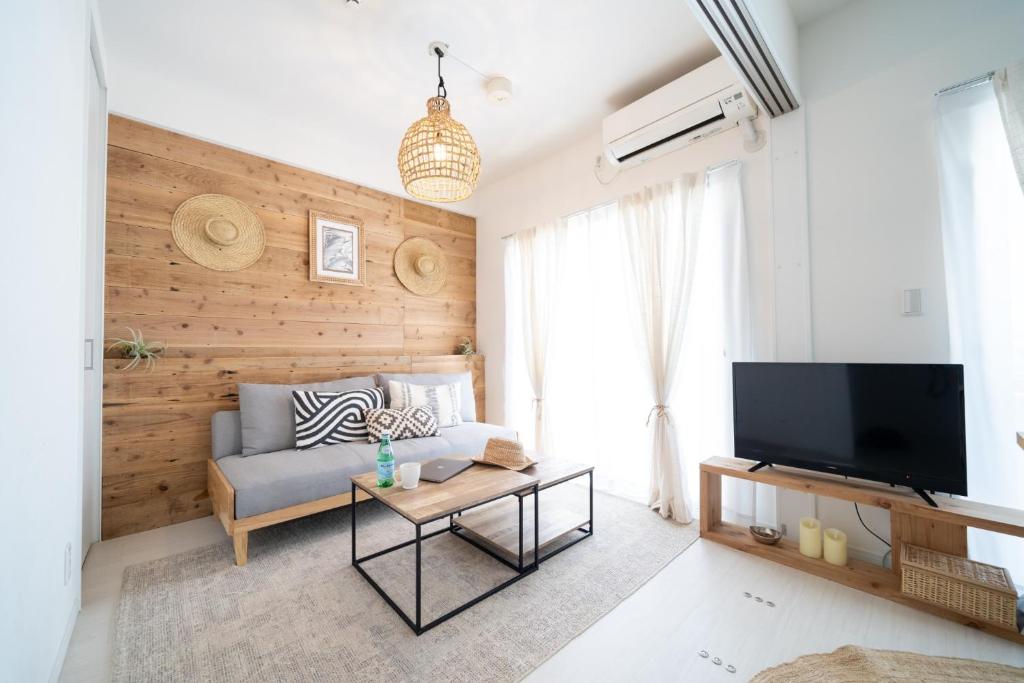a living room with a couch and a tv at Vent du Vent 402 - Vacation STAY 83691v in Urasoe