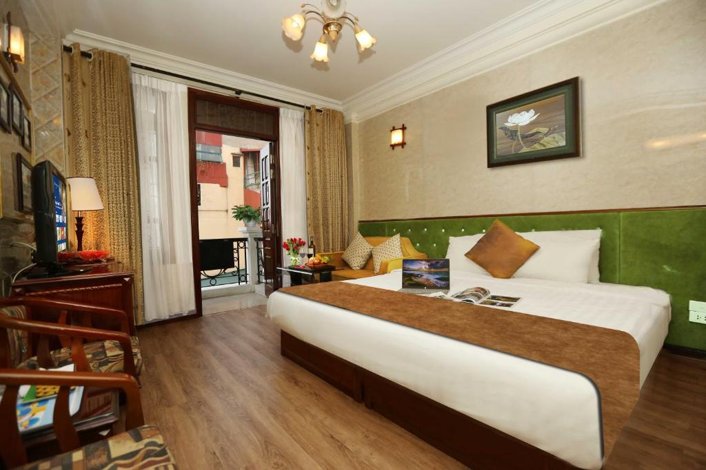 a hotel room with a large bed and a television at Golden Lotus Hotel & Spa in Hanoi