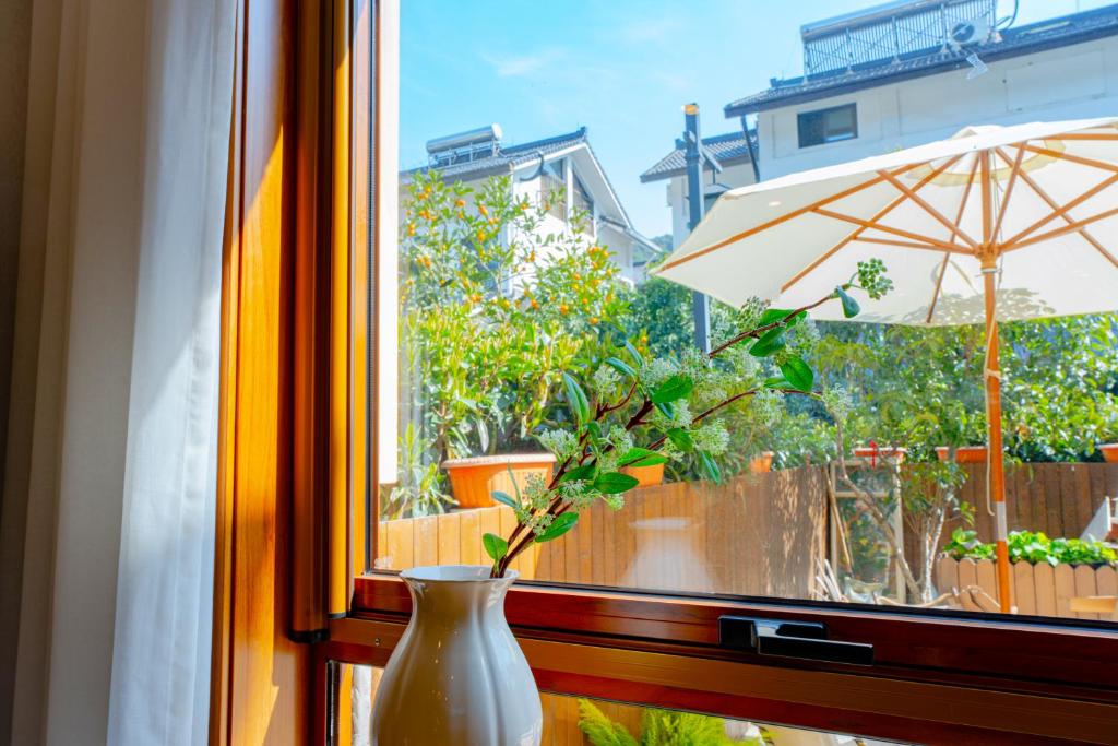 a vase sitting on a window sill with an umbrella at Yi Chen San She in Hangzhou