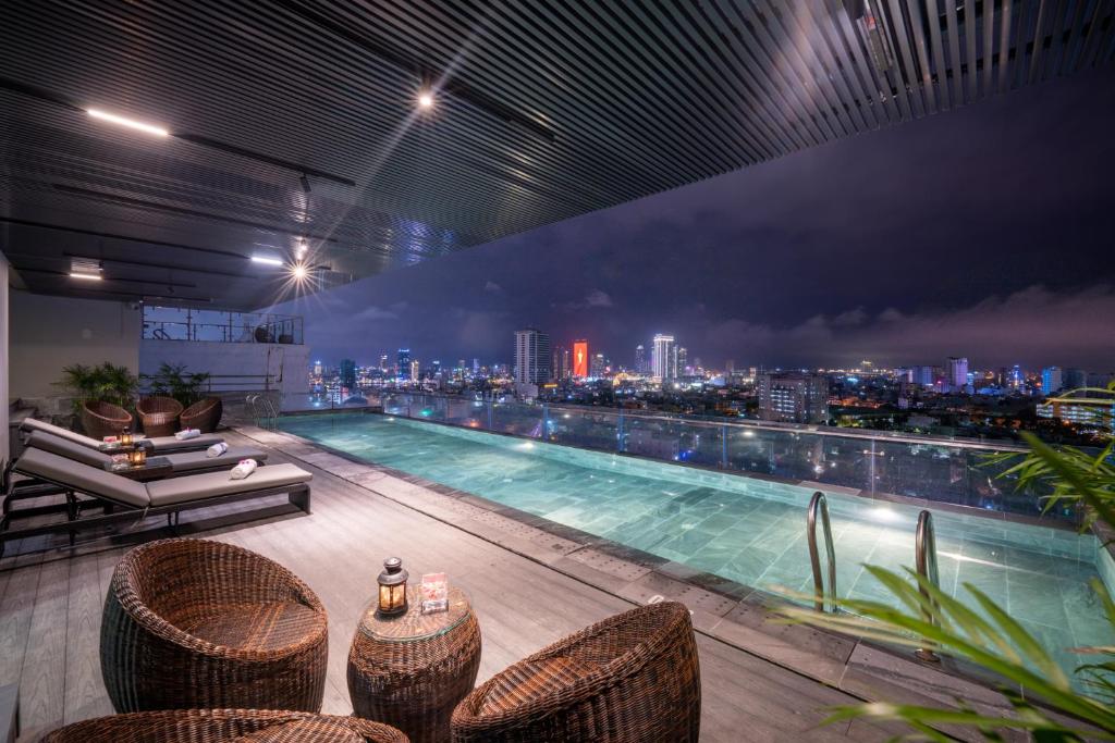 a swimming pool with a view of a city at night at San Marino Boutique Danang in Da Nang