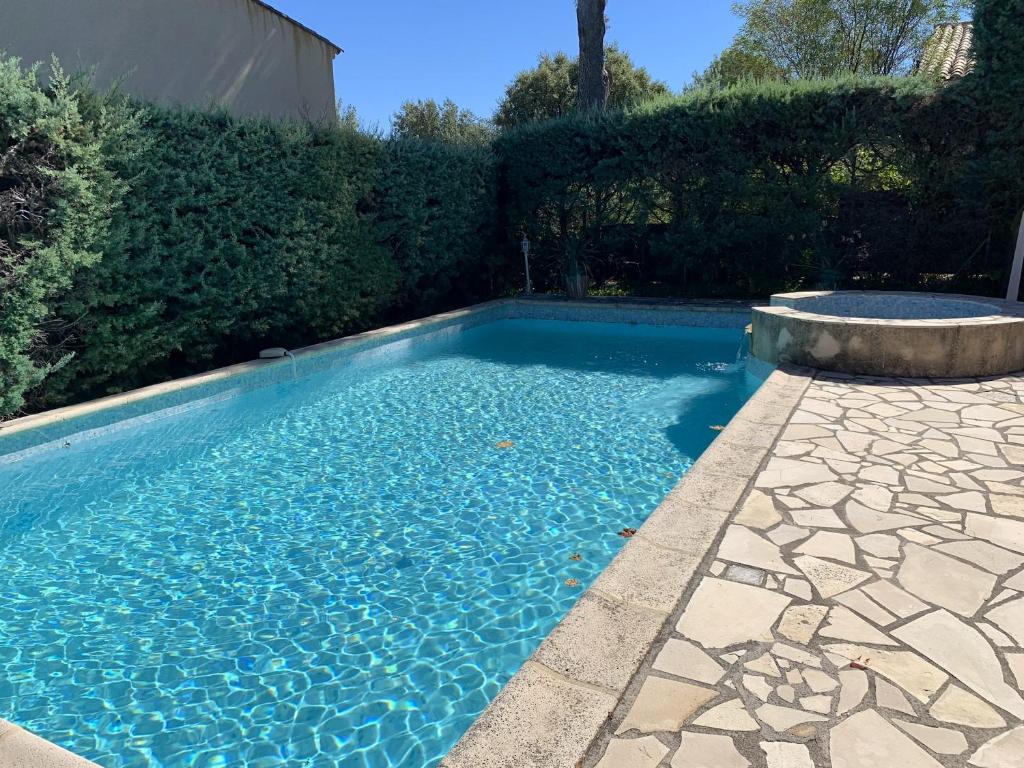 una piscina de agua azul en un patio en Villa de 3 chambres avec piscine privee jardin clos et wifi a Saint Raphael a 6 km de la plage, en Saint-Raphaël