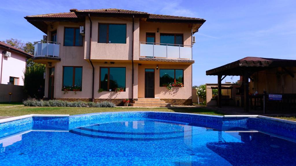 uma casa com piscina em frente a uma casa em Вила Матилда - Villa Matilda em Bulgarevo