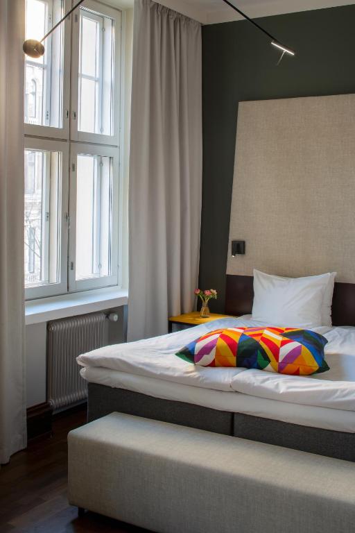 a bedroom with a large bed and two windows at Hotel Klaus K in Helsinki