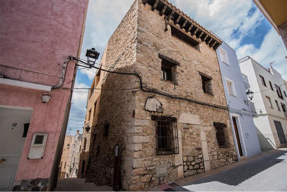 an old stone building on a city street at Casa Rural EL TRULL in Canet lo Roig