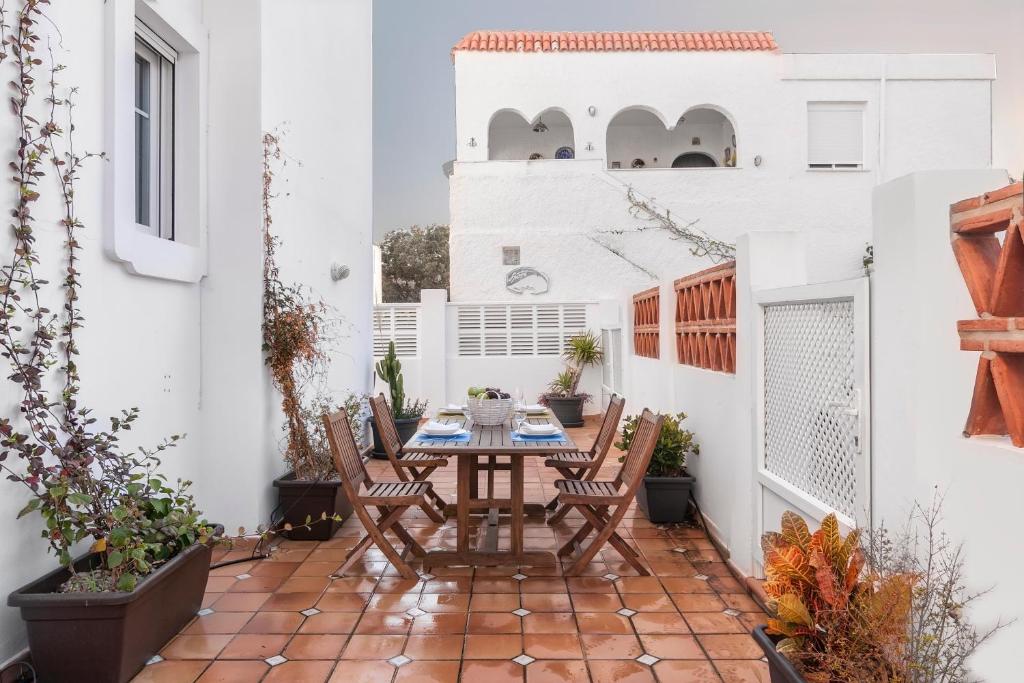 an outdoor patio with a wooden table and chairs at Casa Las Minas in San José