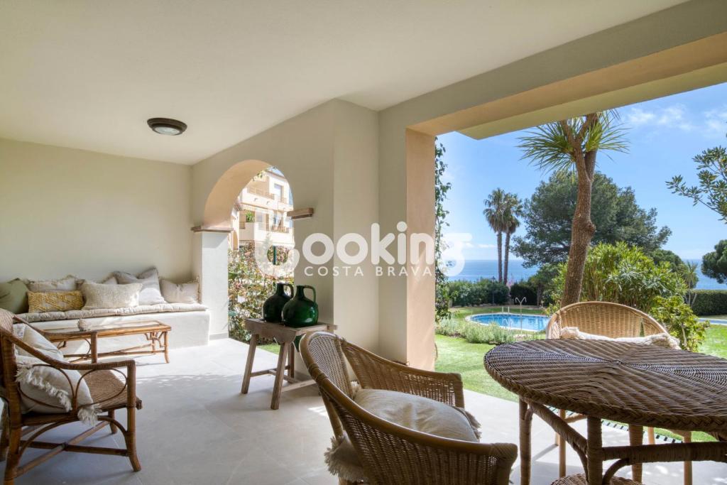 an open living room with a view of the pool at Las Velas I Planta baja en S'Agaró con vista mar y agradable terraza con acceso directo a la piscina in S'Agaro