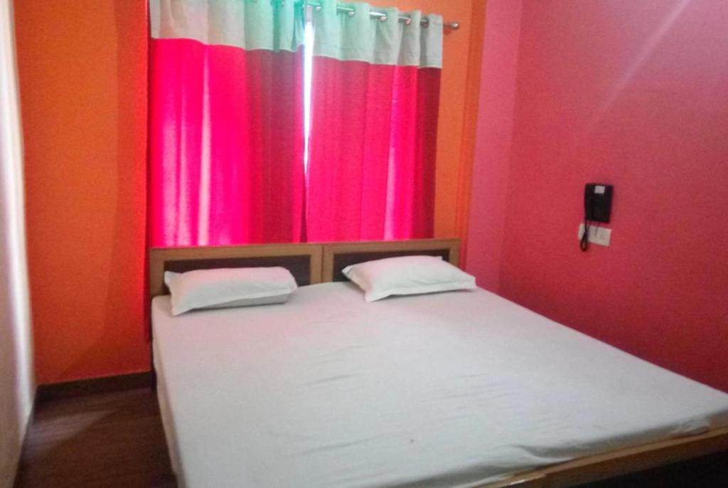 Cama en habitación con cortina colorida en Goroomgo Kashi Inn Varanasi Near Railway Station en Varanasi