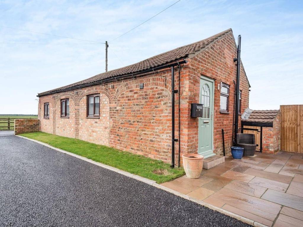 a brick building with a green door on a street at Charming 1 Bedroom Cottage in Doncaster