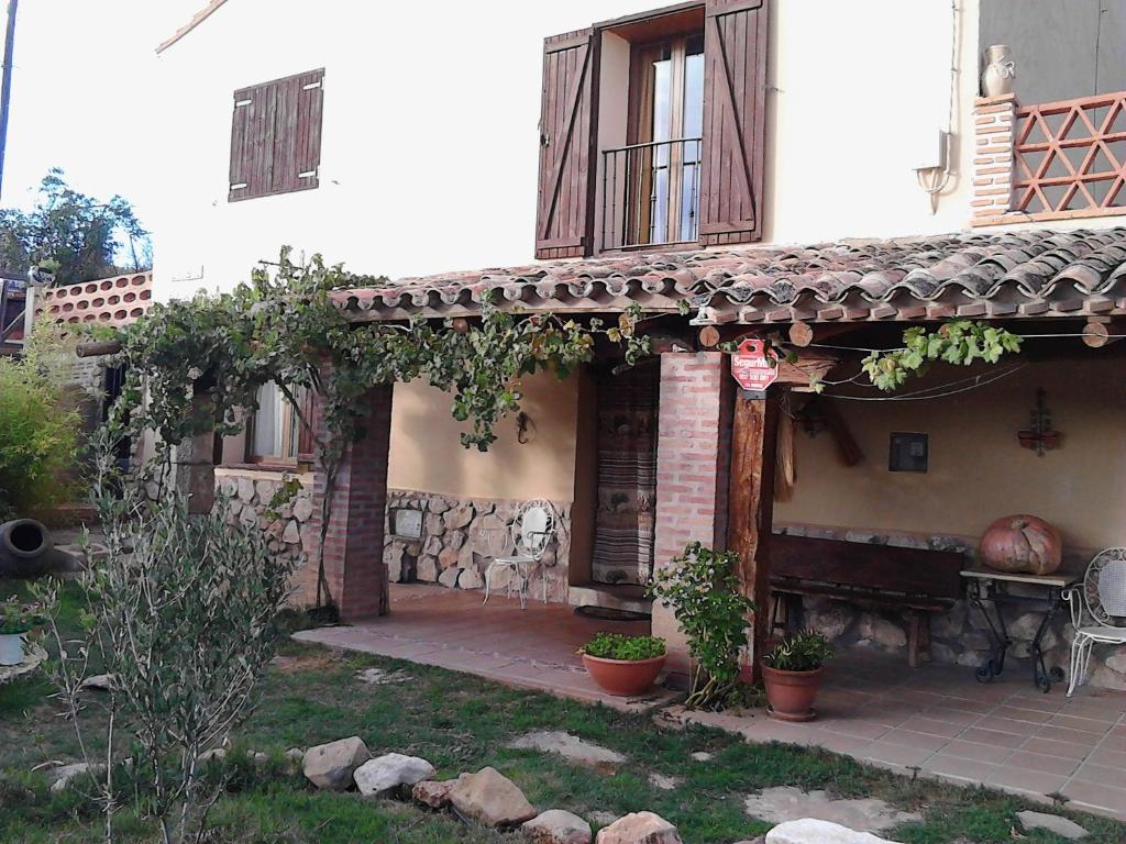 een huis met een veranda en een bank in de tuin bij Casa Blanca in Alhama de Aragón