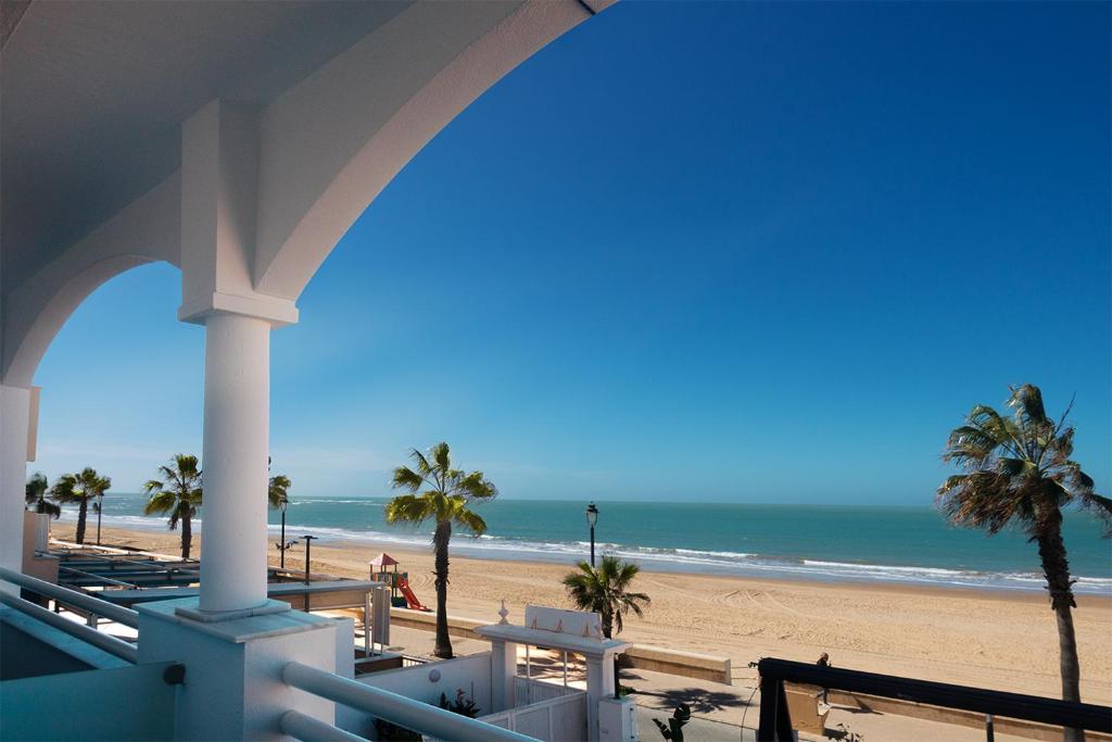 uma vista para a praia a partir da varanda de um resort em Hotel Vértice Chipiona Mar em Chipiona