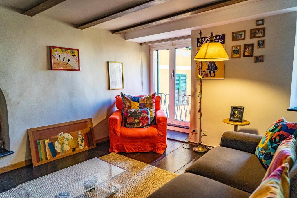 uma sala de estar com uma cadeira vermelha e um sofá em Martina Guest House em Gênova