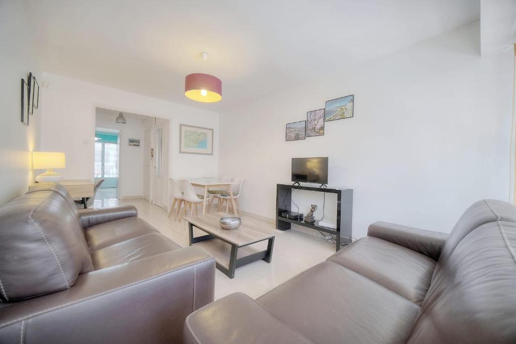 un salon avec un canapé et une table dans l'établissement IMMOGROOM - Renovated apartment - Terrace - AC, à Cannes