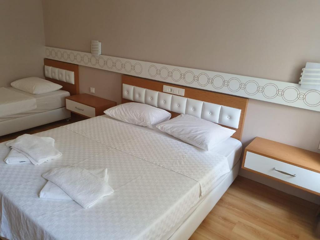 a bedroom with a large white bed with two pillows at Terko hotel pansiyon in Beldibi