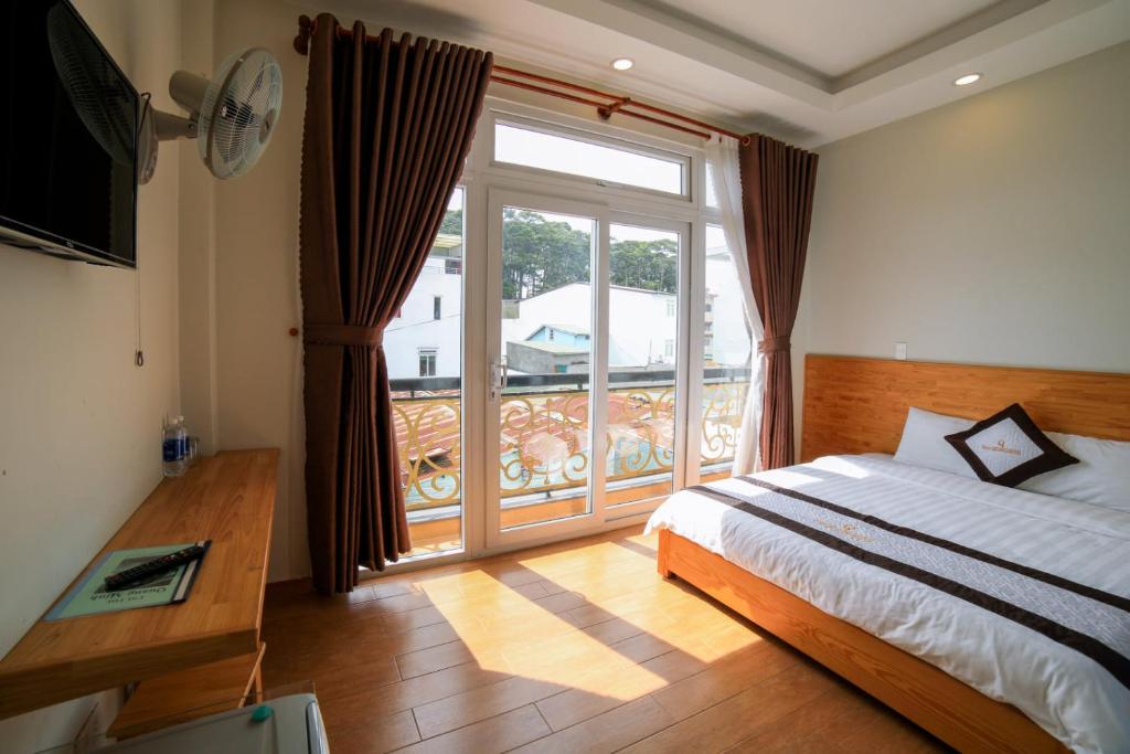 a bedroom with a bed and a large window at Quang Minh Dalat Hotel in Da Lat