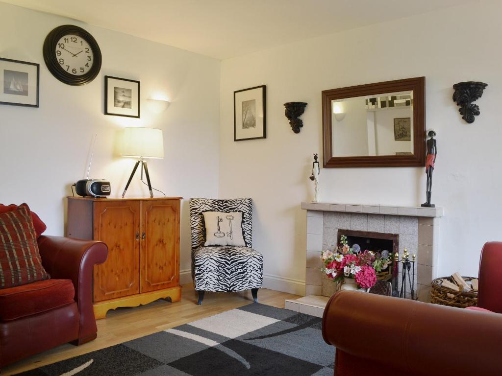 a living room with a fireplace and a mirror at Checkers Cottage - Beaufort Estate in Belladrum