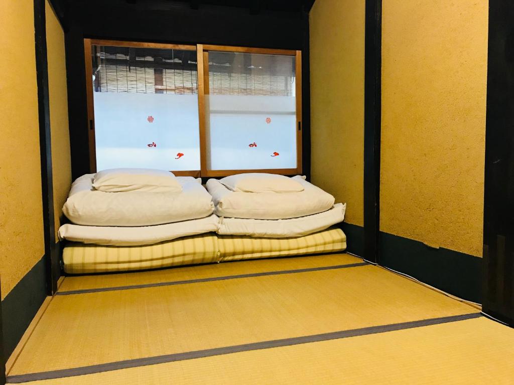 Łóżko lub łóżka w pokoju w obiekcie Nagomi-Ryokan Yuu