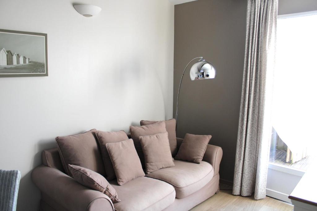 a couch sitting in a living room with a window at Fleur de Ré in Loix