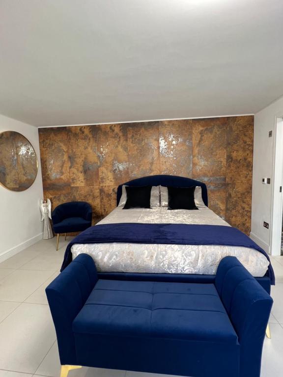 a bedroom with a blue bed and a blue couch at Garden View in Northfleet