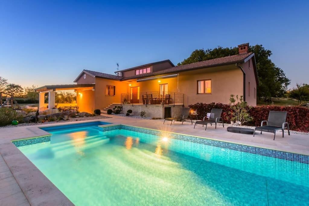 a large swimming pool in front of a house at Villa Emini by IstriaLux in Novaki Motovunski