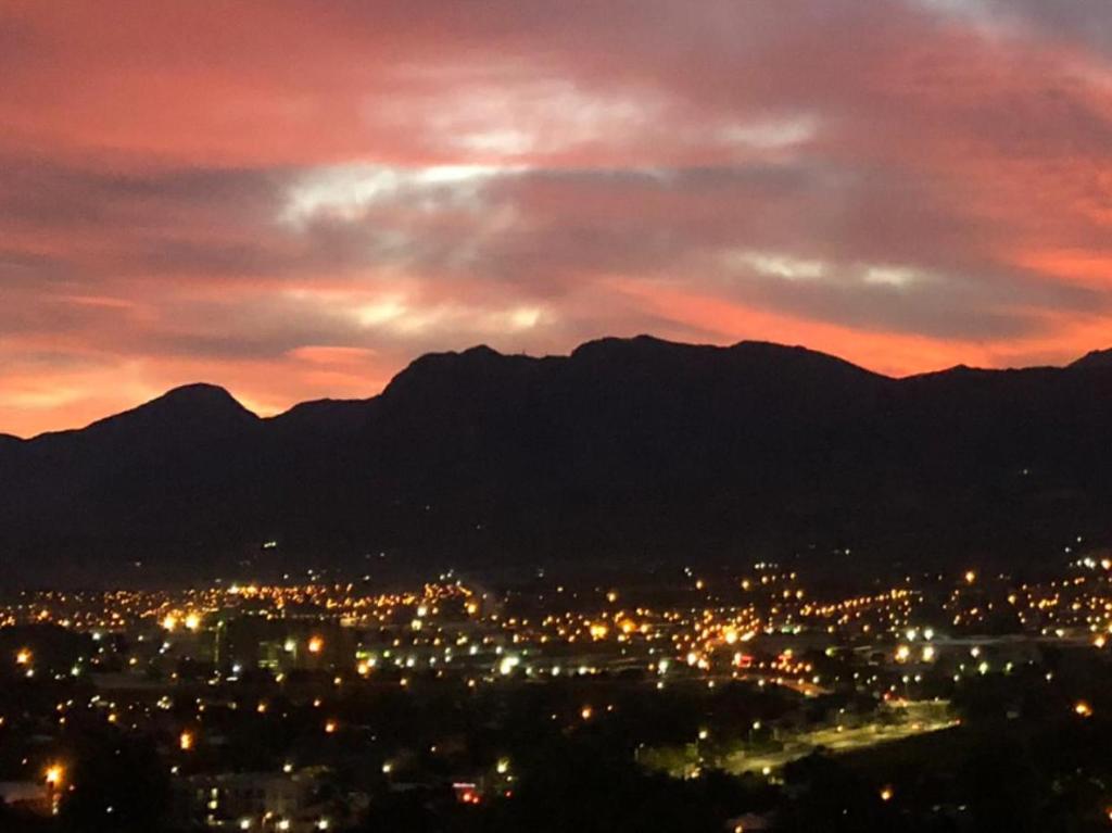 a city lit up at night with mountains in the background at Paarl Views in Paarl