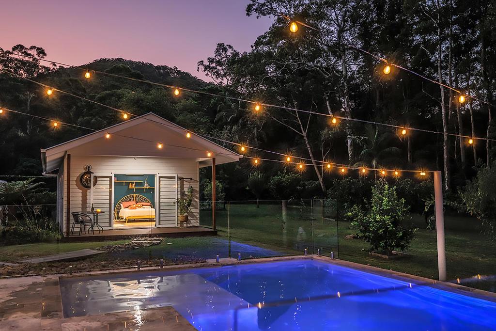 uma casa com piscina à noite com luzes em The Poolhaus Retreat - Peaceful Private Studio em Valdora