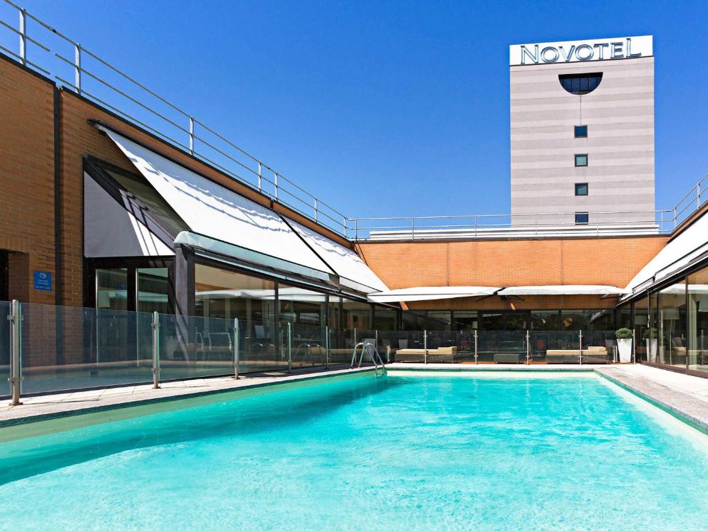 una grande piscina di fronte a un edificio di Novotel Milano Linate Aeroporto a Milano