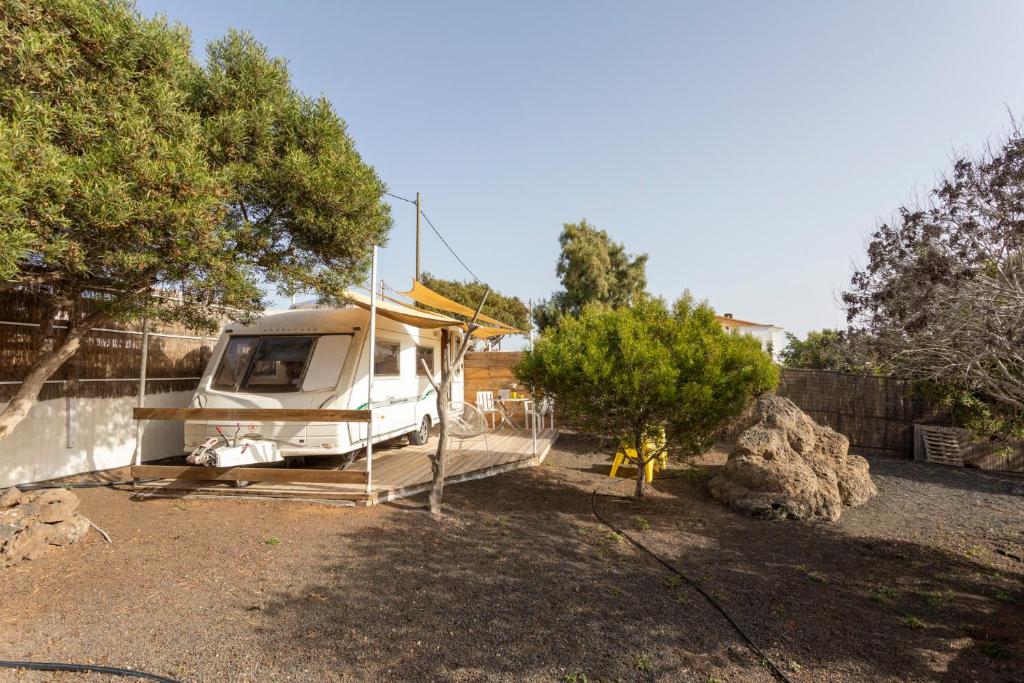a white rv parked in a yard next to a fence at Villaverde Glamping in Villaverde