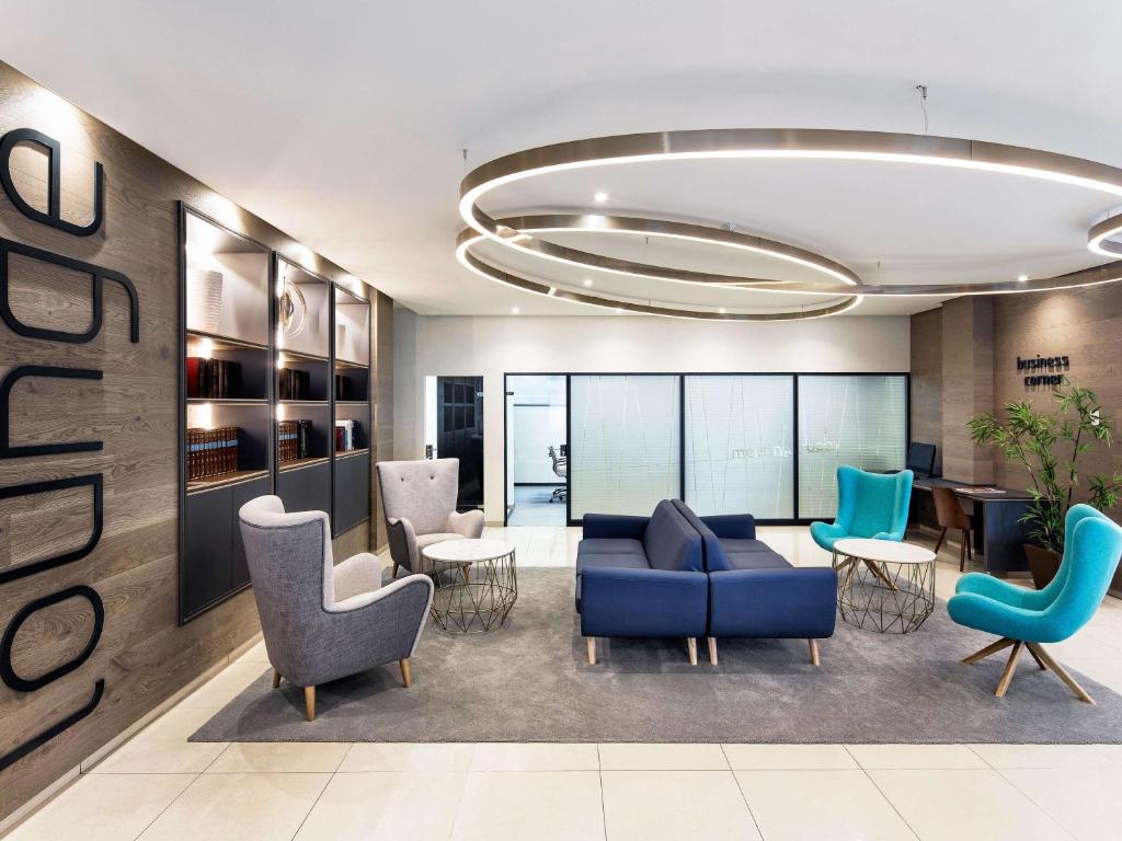 an office lobby with a blue couch and chairs at Ibis Styles A Coruna in A Coruña