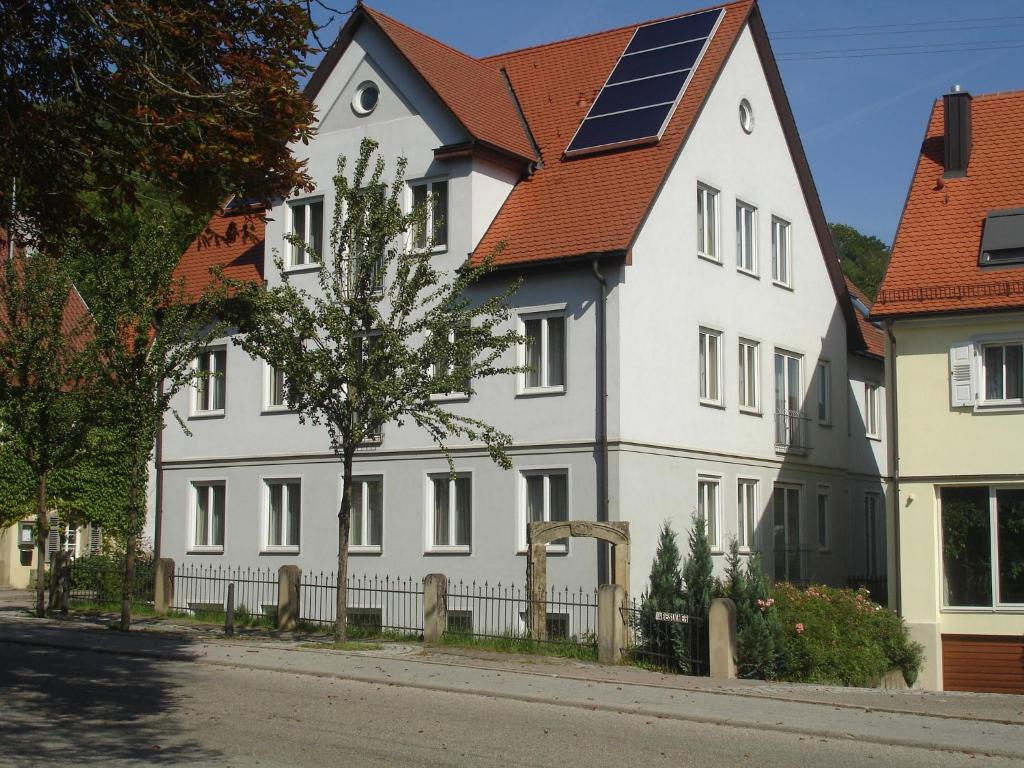 a white house with a solar roof on a street at Apartment 4 in Braunsbach