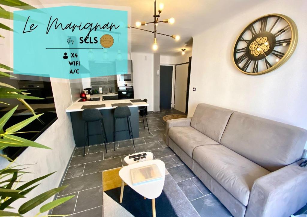 un salon avec un canapé et une horloge au mur dans l'établissement Le Marignan By SCLS Locations, à Cannes