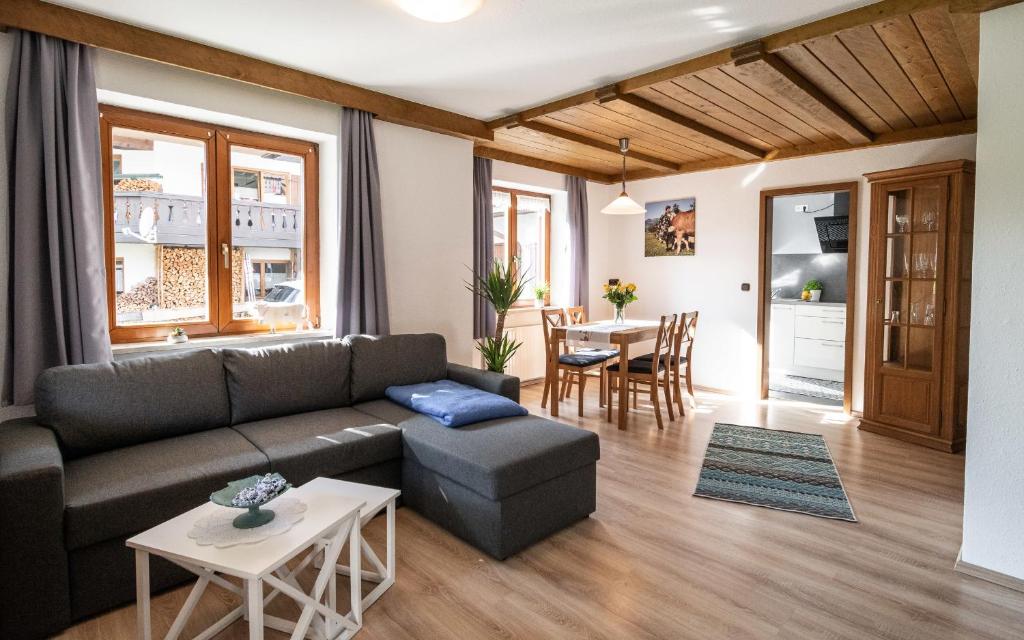 un soggiorno con divano e tavolo di Neu! Sonnige Terrassen-Ferienwohnung in den Bergen a Bad Hindelang