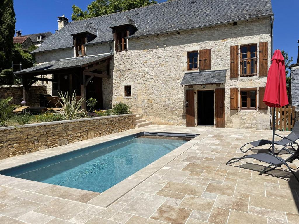 dom z basenem przed budynkiem w obiekcie Charme & piscine chauffée Périgord Noir w mieście Coly