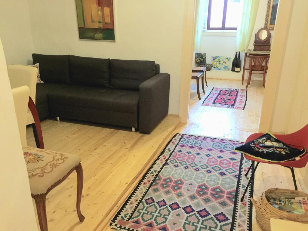 ein Wohnzimmer mit einem Sofa und einem Teppich in der Unterkunft Brač, Supetar, ART HOUSE, Dreamy Dalmatian vacation home, 80m from sea in Supetar