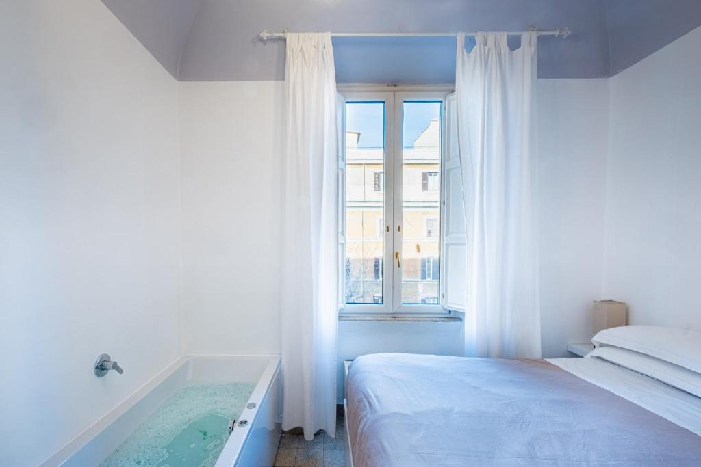um quarto com uma cama e uma banheira ao lado de uma janela em My Tiny Home Alchemy em Roma