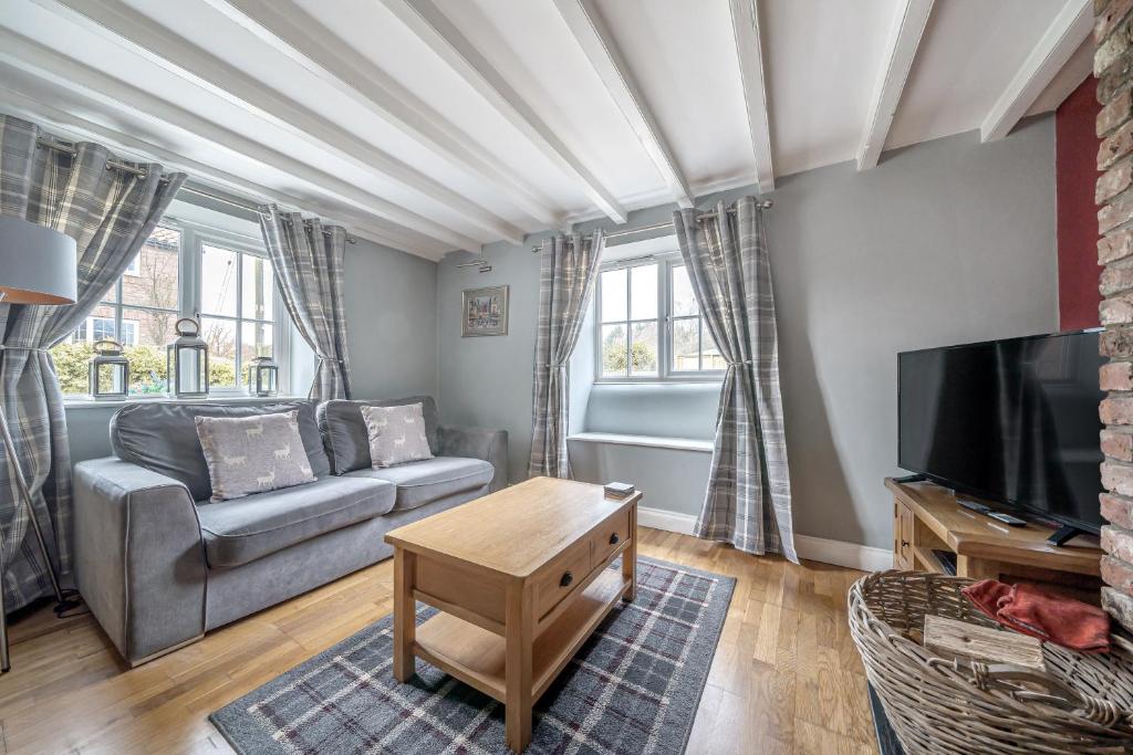 a living room with a couch and a tv at Host & Stay - Great Habton Cottage in Malton