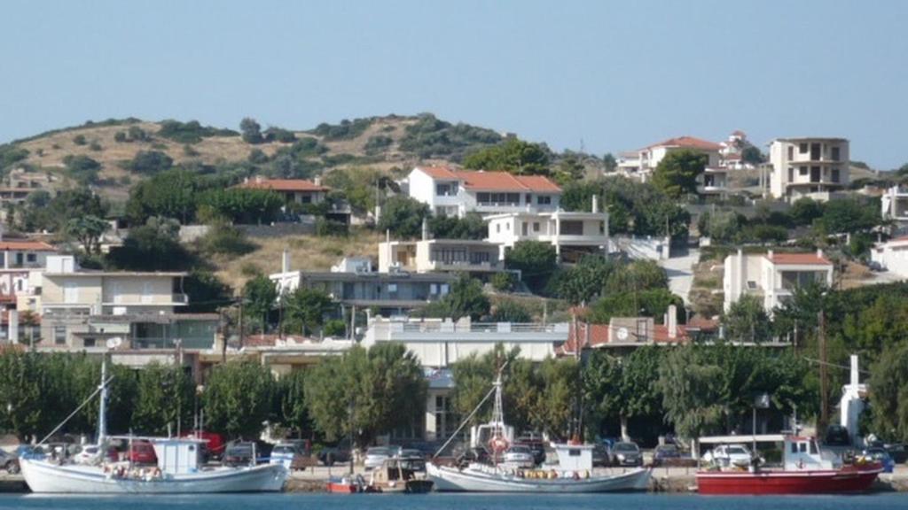 un grupo de barcos atracados en un puerto con casas en Studio Μαρίνος 'Αγιοι Απόστολοι Πετριές, en Agioi Apostoli