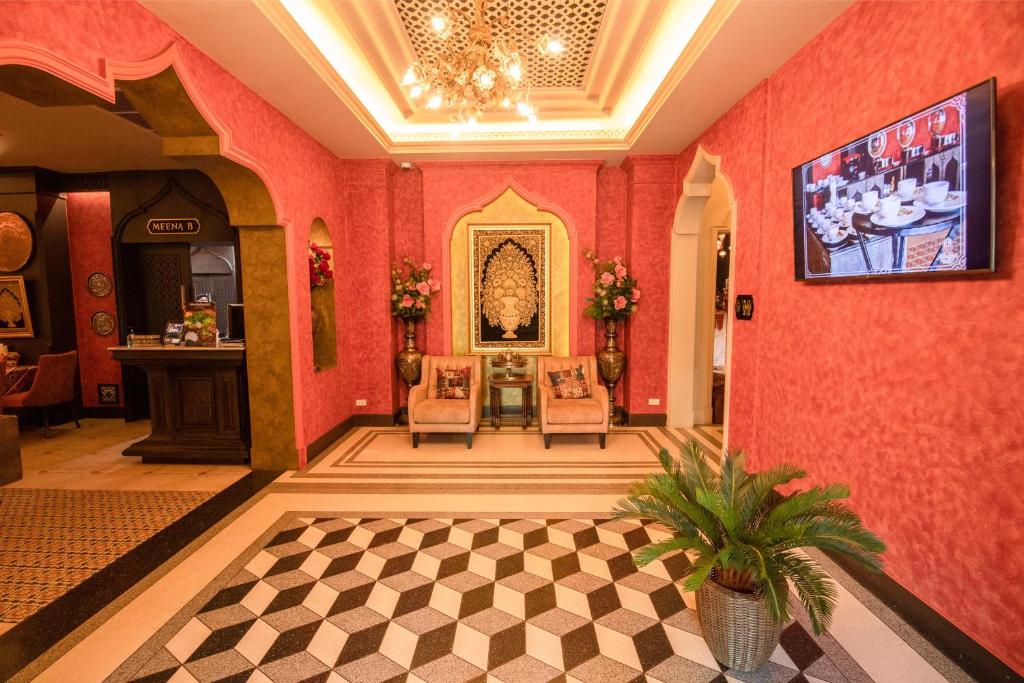 a lobby with red walls and a checkered floor at Amman Unique Hotel in Udon Thani