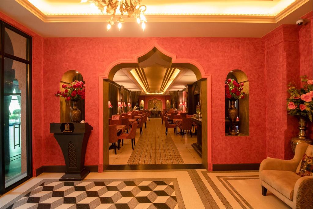 a restaurant with red walls and tables and chairs at Amman Unique Hotel in Udon Thani