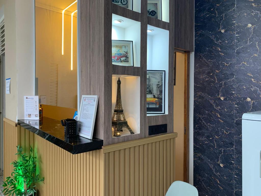 a reception desk with a replica of the eiffel tower at Pousada Internacional EAS Airport 10min in Guarulhos