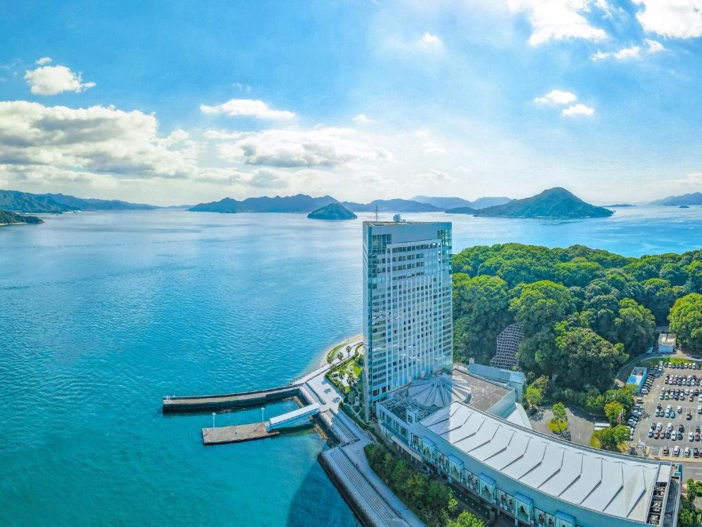 a tall building next to a large body of water at Grand Prince Hotel Hiroshima in Hiroshima