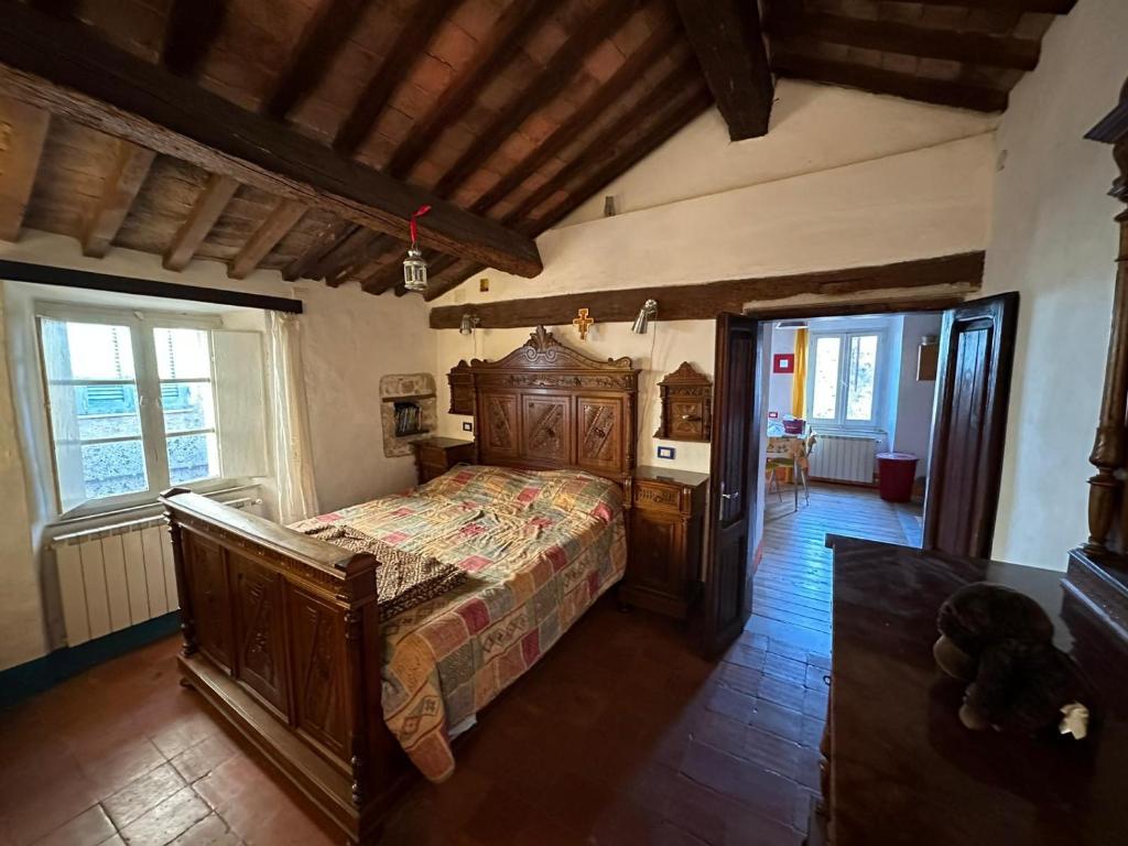 ein Schlafzimmer mit einem großen Holzbett in einem Zimmer in der Unterkunft Corte delle Oche in Semproniano