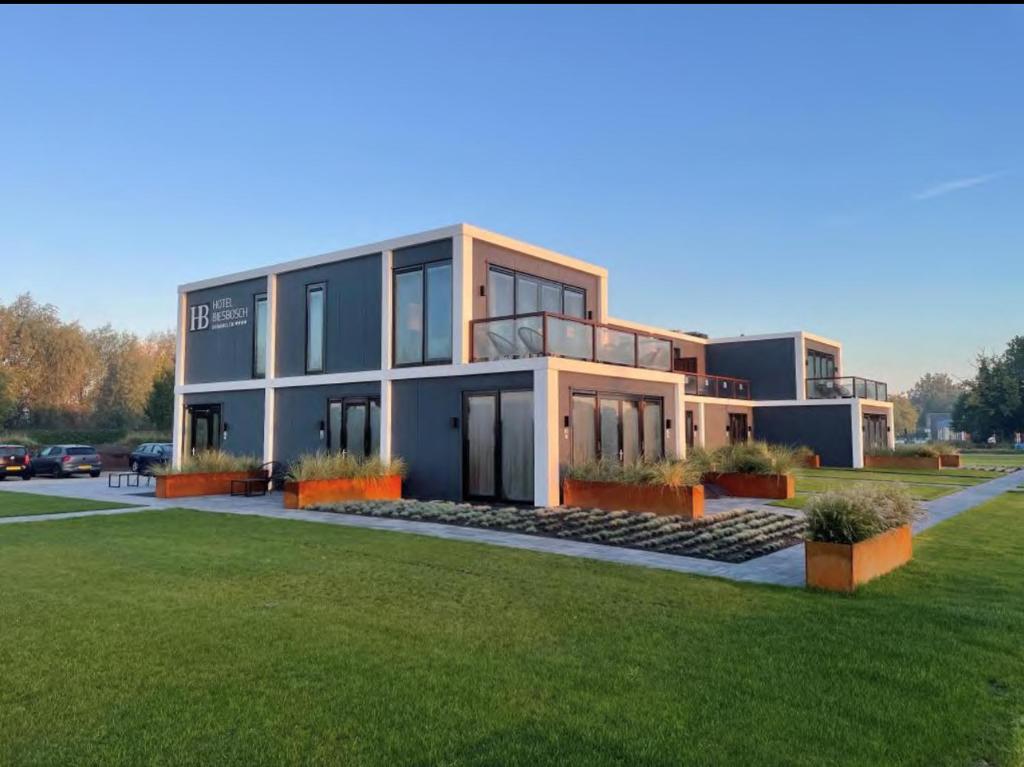 a large house with a green lawn in front of it at Hotel Biesbosch in Drimmelen